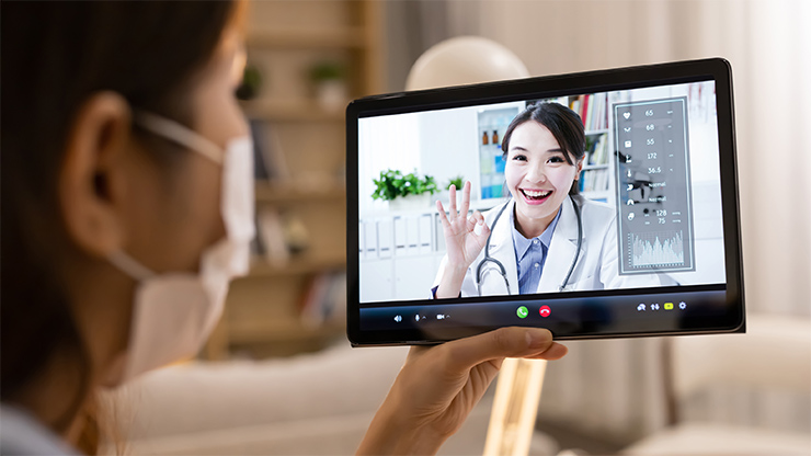 Una mujer utilizando servicios de revisión médica en línea en varios dispositivos